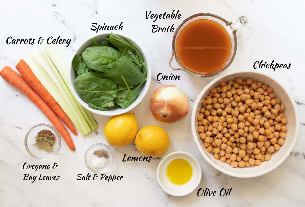 Chickpea soup ingredients: carrots, celery, spinach, vegetable broth, onion, chickpeas, olive oil, lemons, salt, pepper, oregano, bay leaves.

