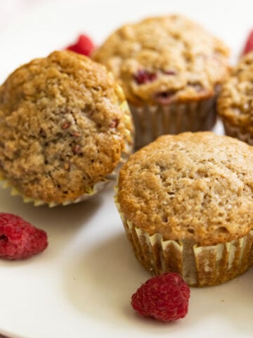 Close up of vegan raspberry muffins on white plate.