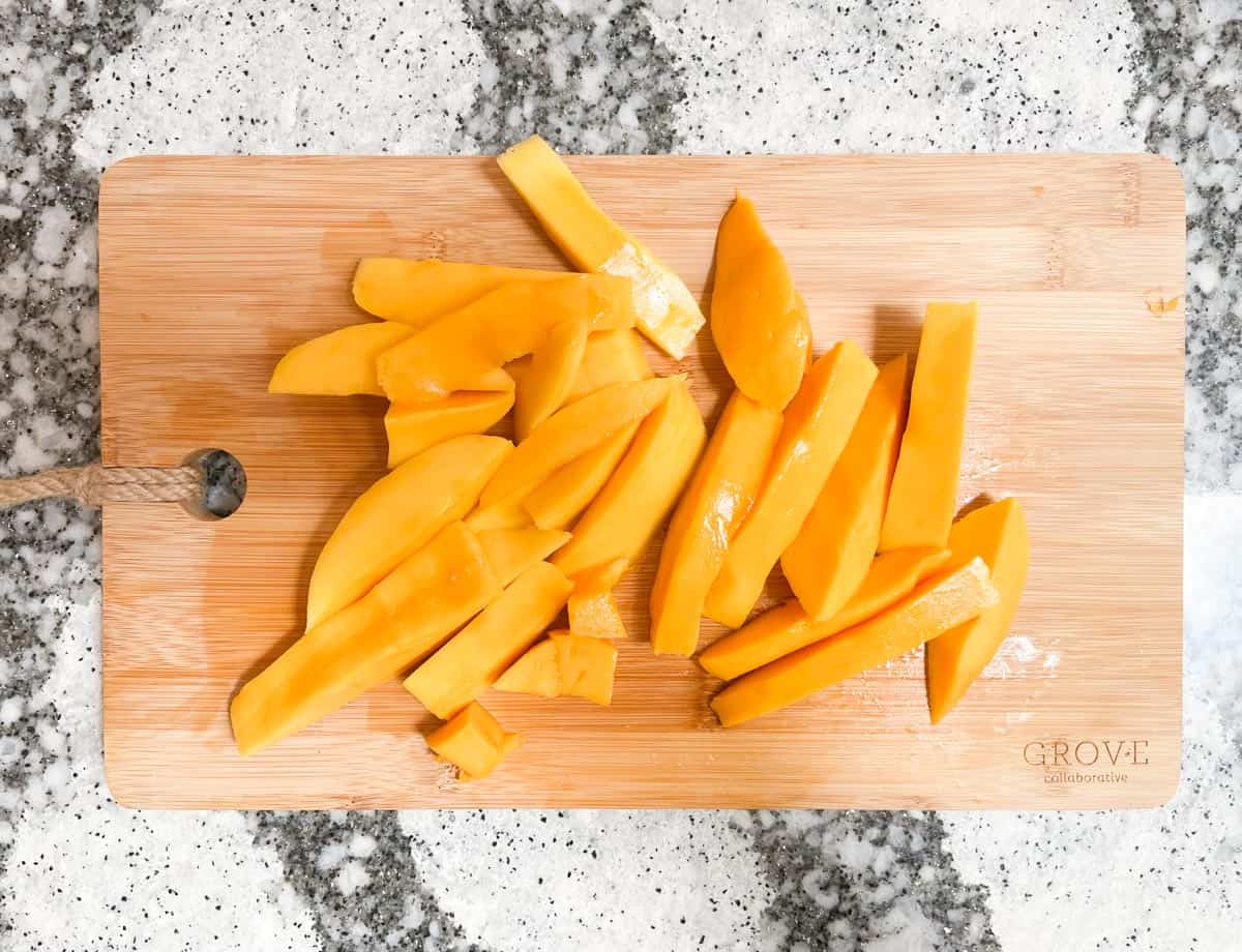 Sliced mango on cutting board.