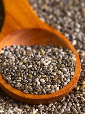 Close-up of chia seeds on wood spoon.
