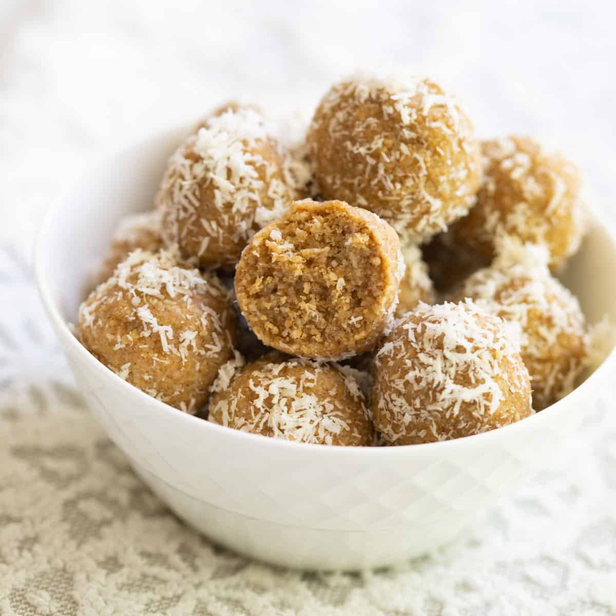 Coconut bliss balls in small white bowl.