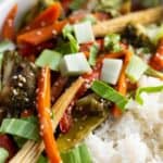 Close up of vegetable stir-fry served with rice.