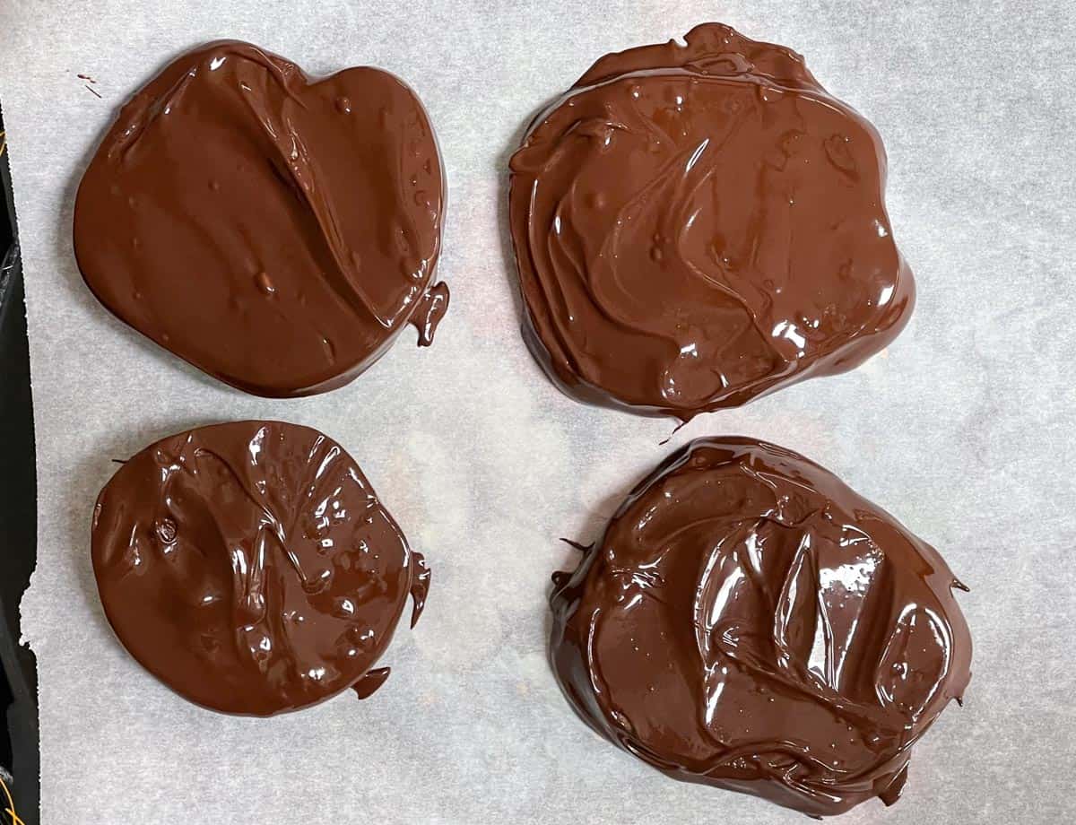 Chocolate covered apple slices on parchment paper. 
