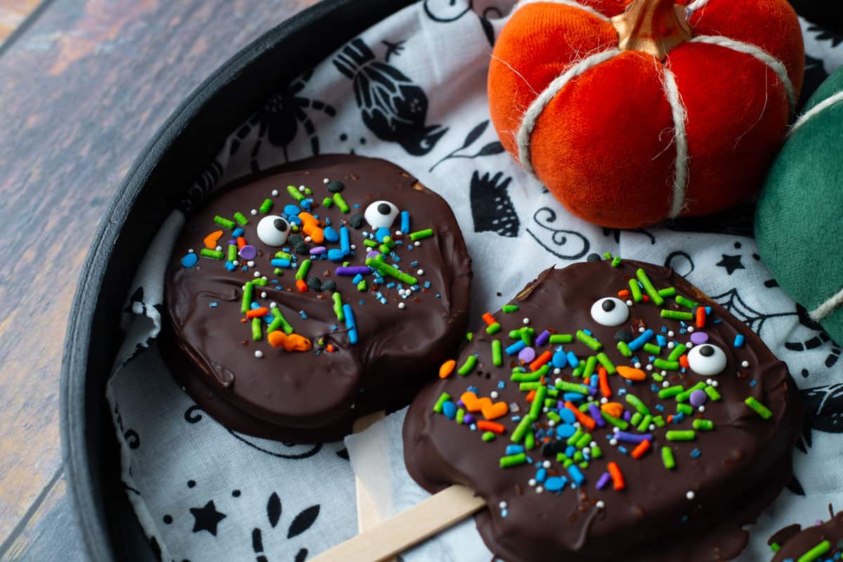 Halloween Apple slices covered in chocolate on serving tray.