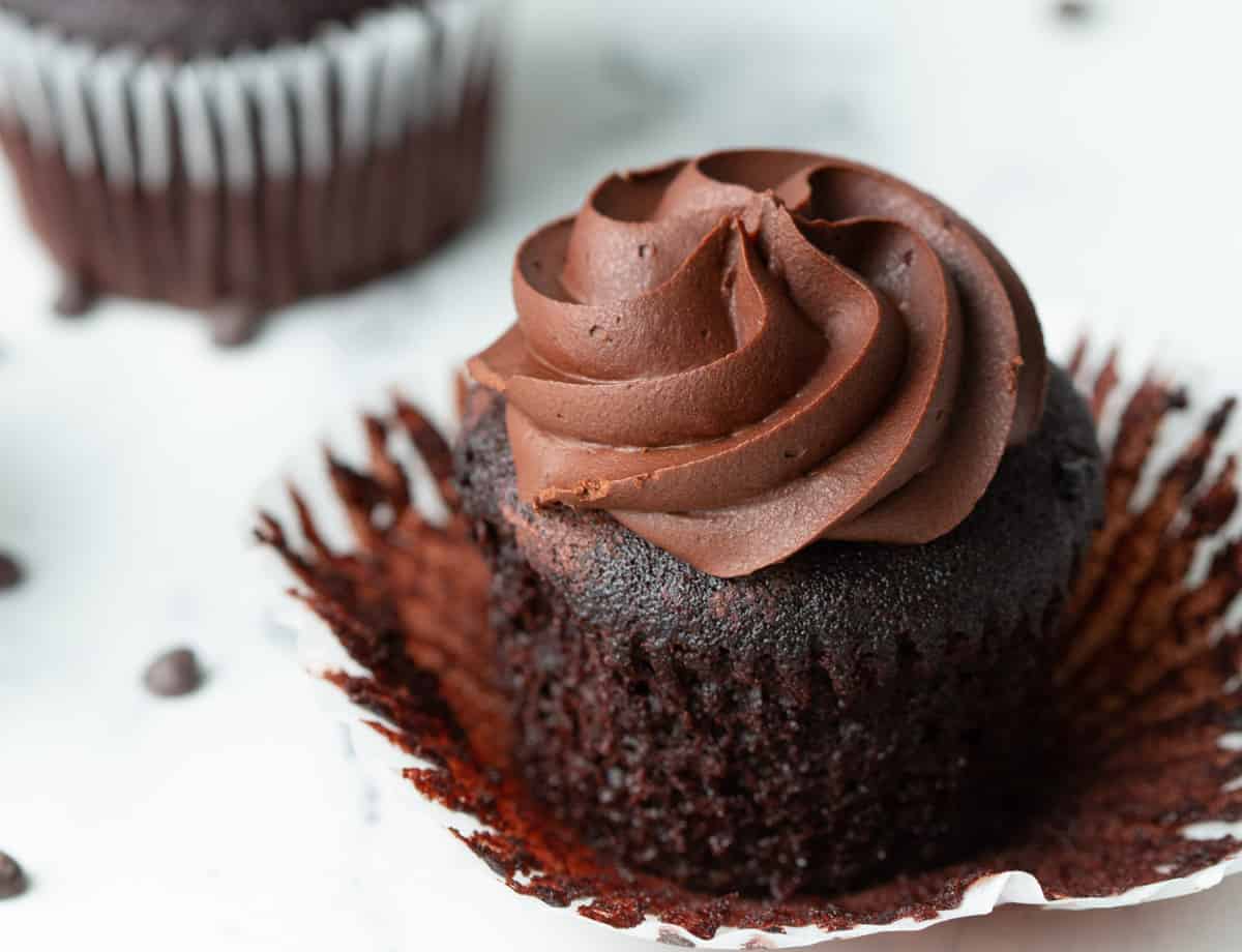 Vegan chocolate cupcake with chocolate frosting with wrapper removed.
