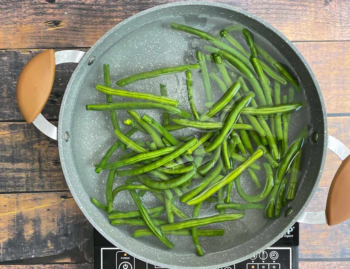 Green beans in pot of boiling water.

