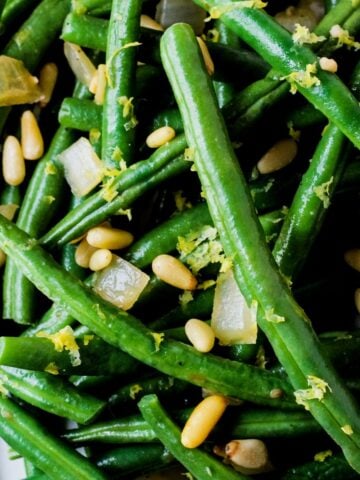 Vegan Green beans with lemon zest and pine nuts.