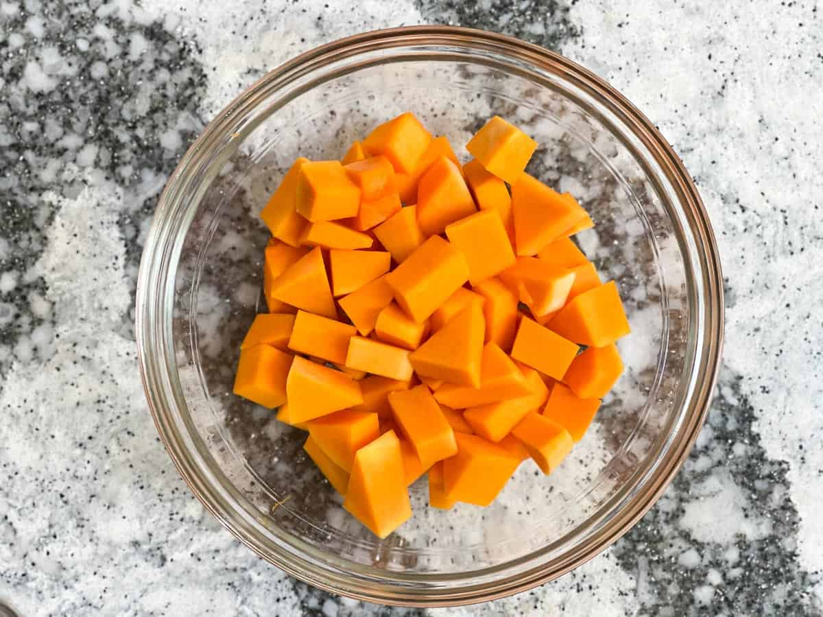 Cubed butternut squash in a glass mixing bowl.
