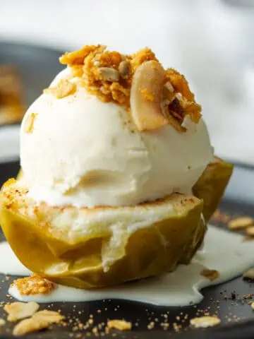 Baked apple half topped with ice cream and granola.