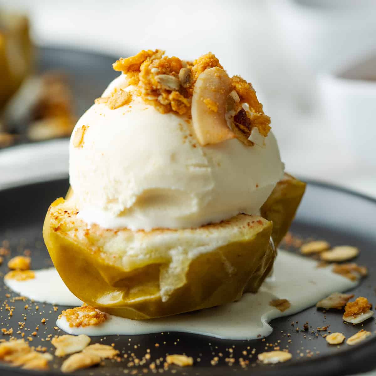 Vegan Baked apple half served with ice cream and granola.
