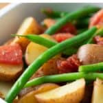 Potatoes and green beans in stewed tomato sauce.