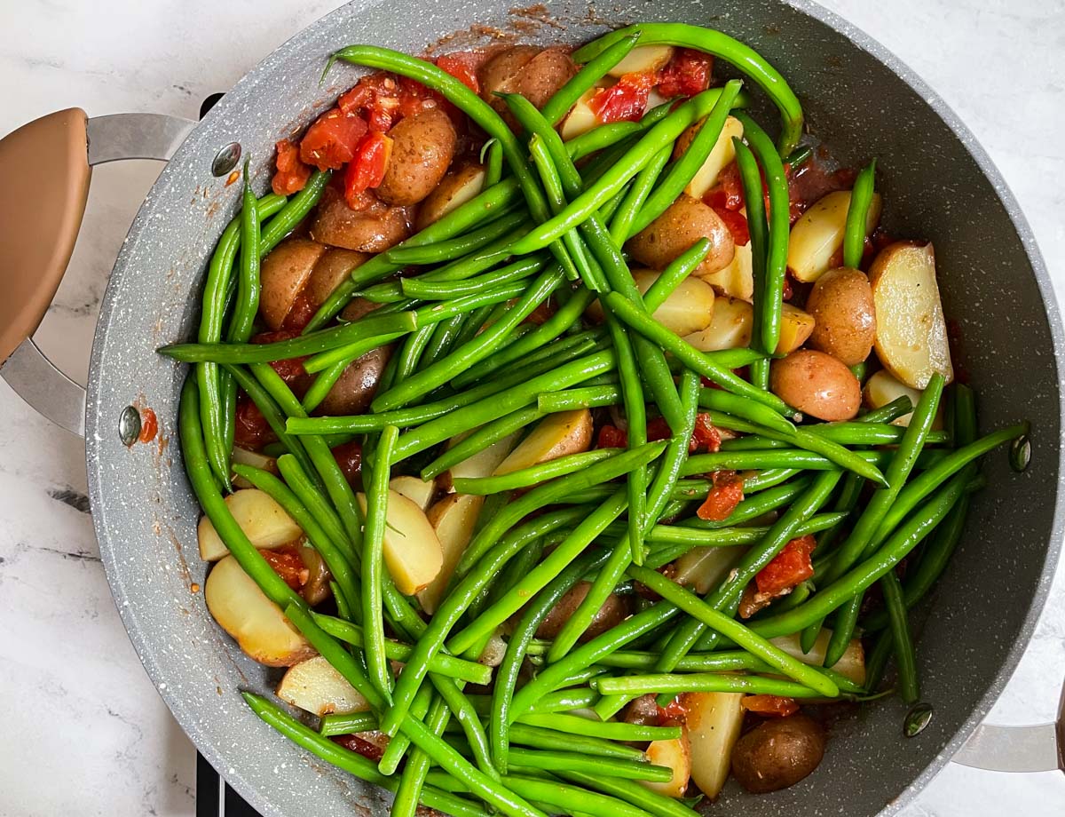 Green beans, potatoes, and tomatoes in large pot.