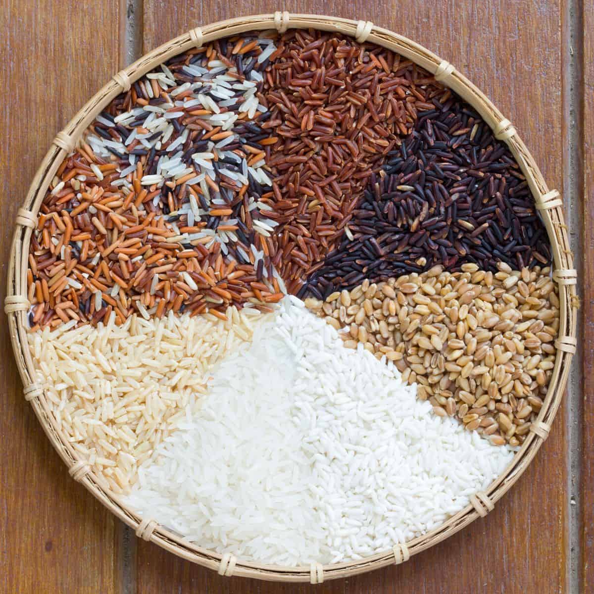 Circular basket filled with different varieties of rice. 