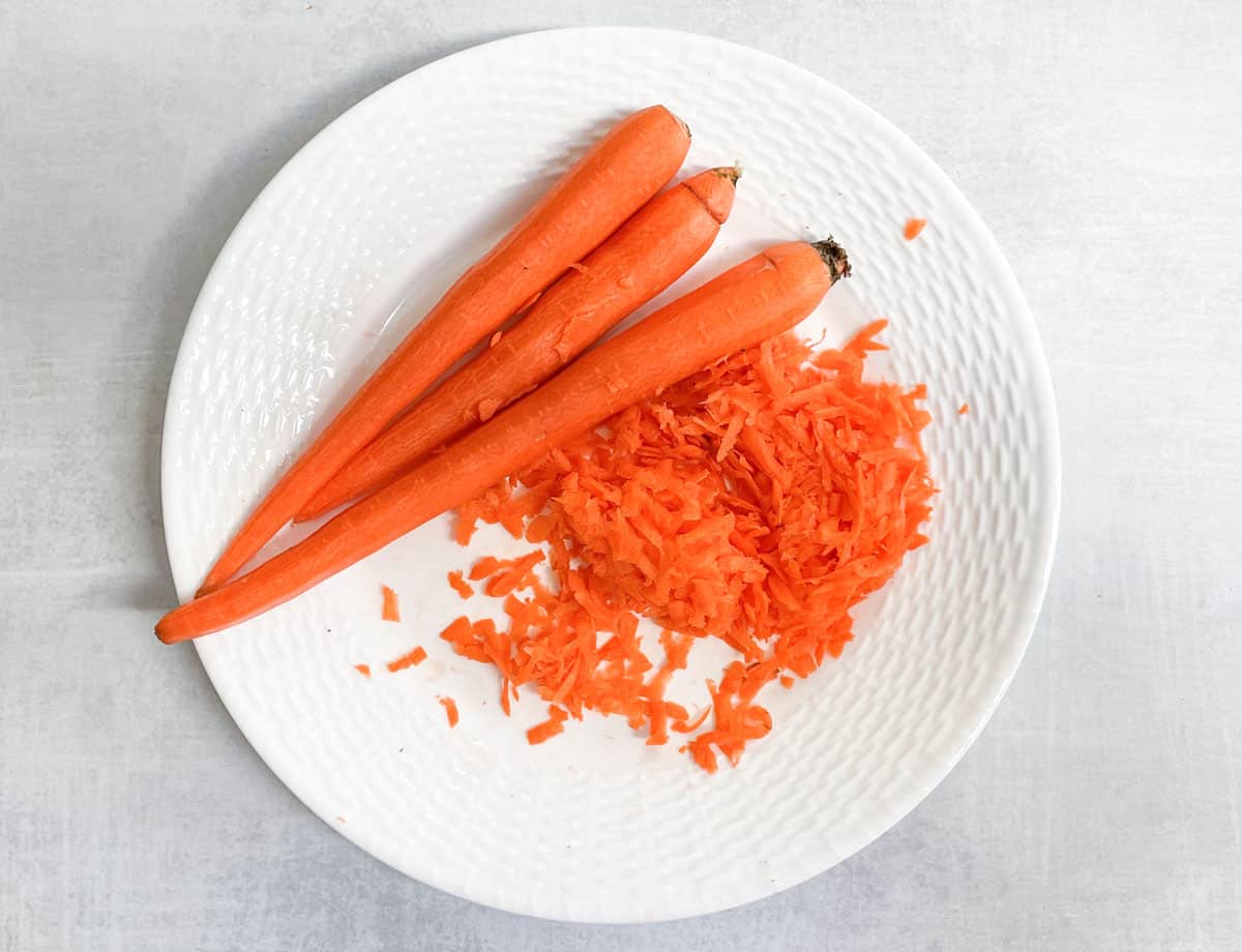Carrots, and shredded carrots on plate. 