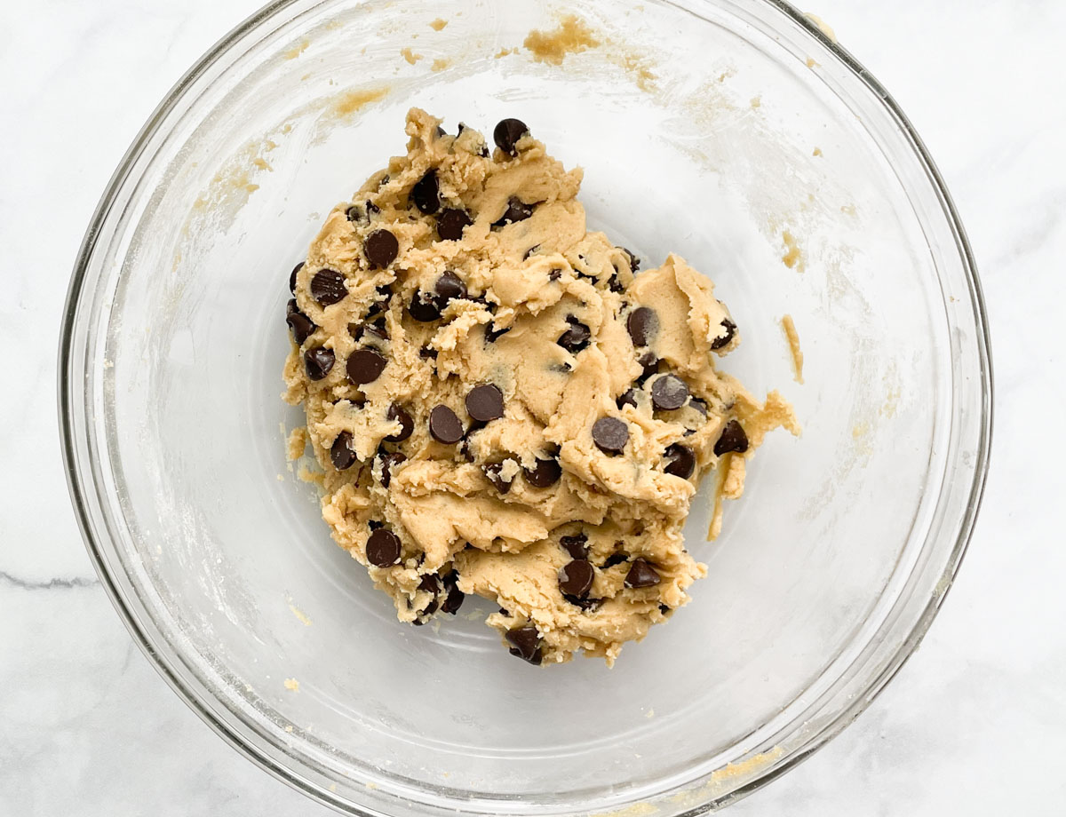 Chocolate chip cookie dough in mixing bowl.
