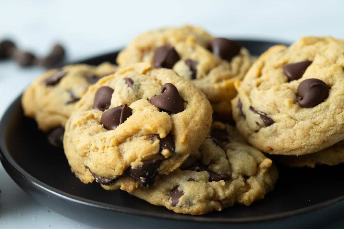 Eggless chocolate chip cookies on black plate.
