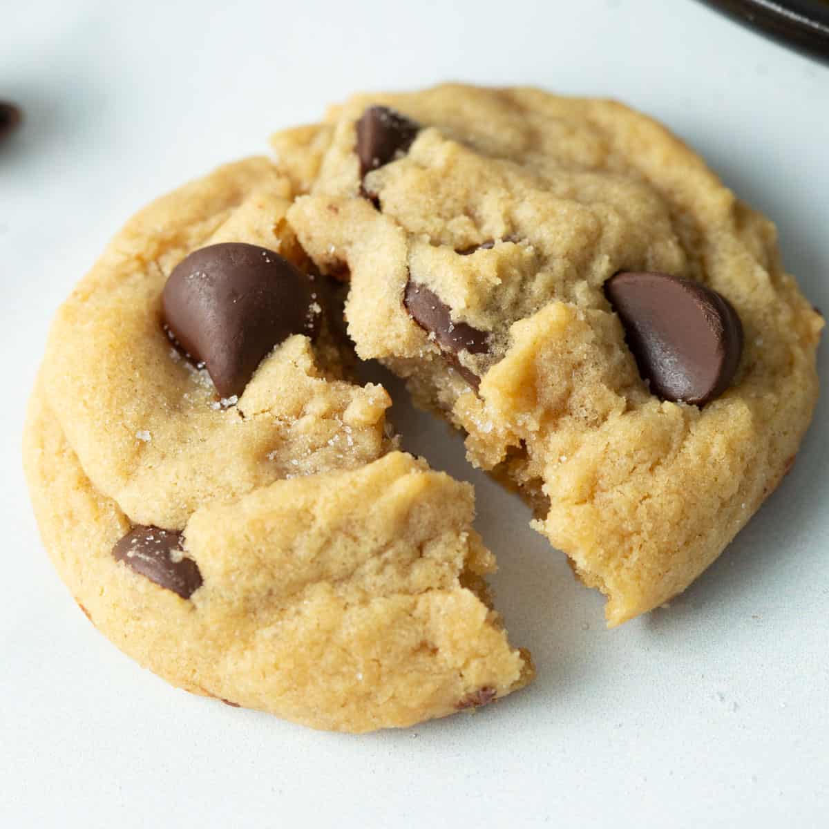 Eggless chocolate chip cookie broken in half.