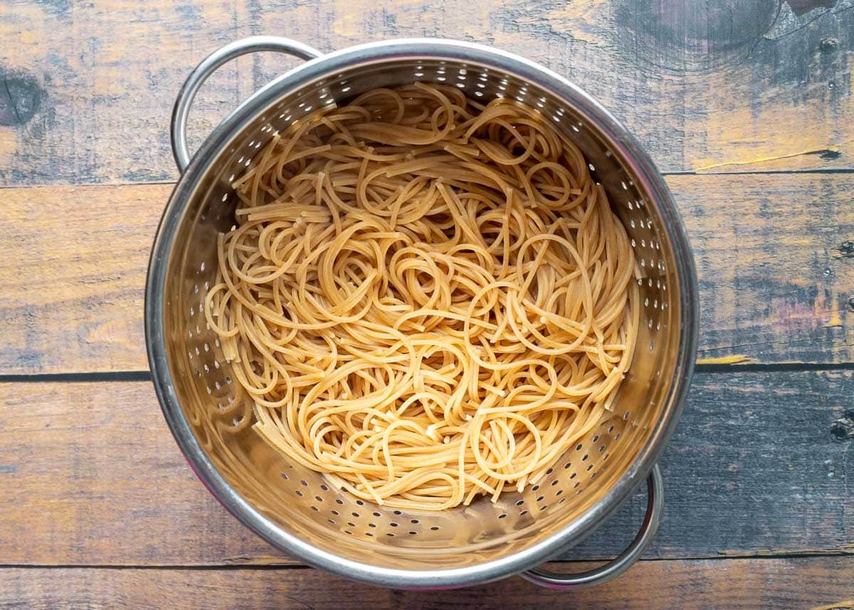 Whole wheat spaghetti in colander.