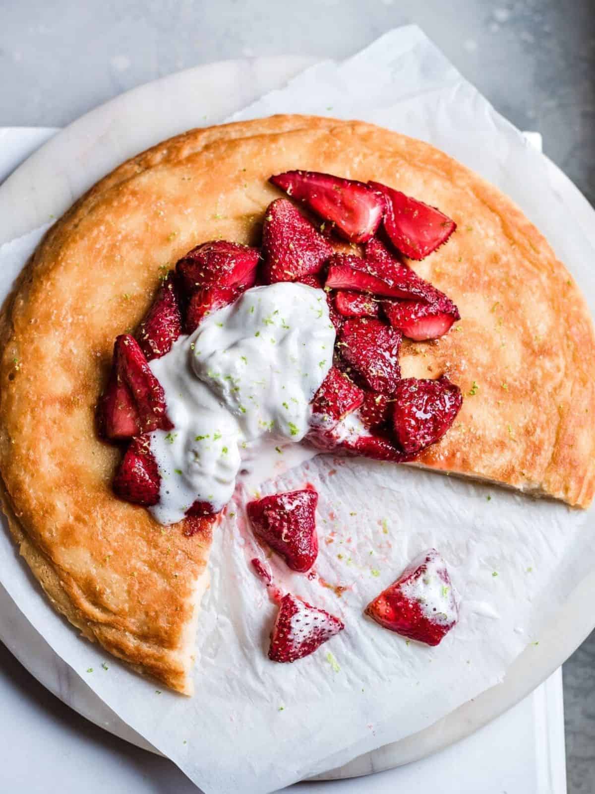 Vegan Dutch Baby topped with strawberries and cream. 