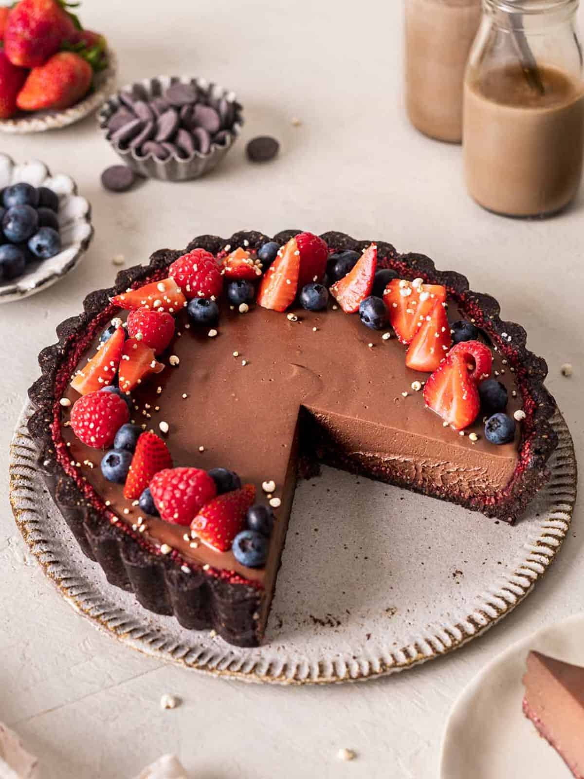 Vegan chocolate tart topped with fresh berries.