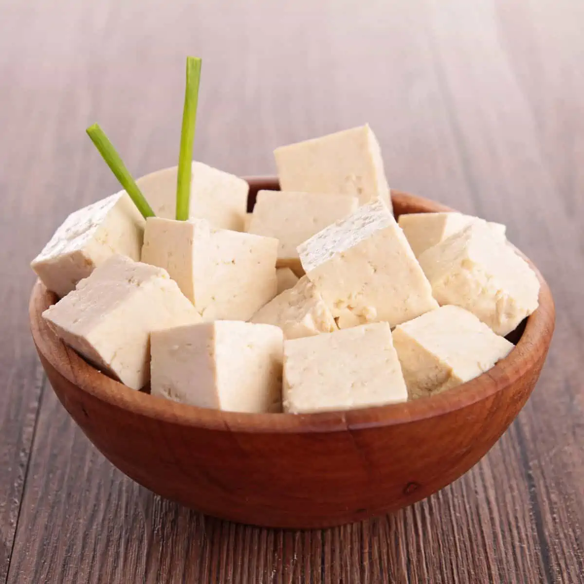 Cubed tofu in wood bowl.
