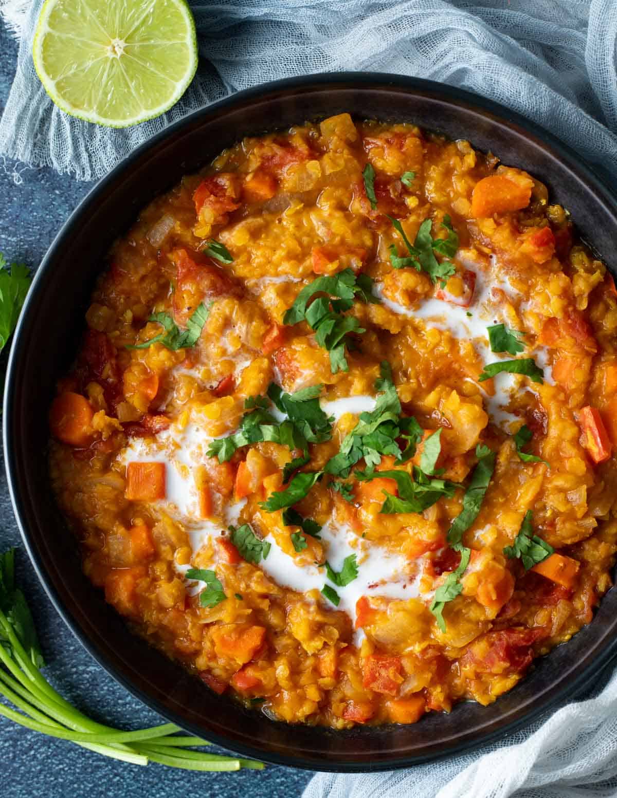 Vegan lentil curry topped with cilantro and coconut cream.