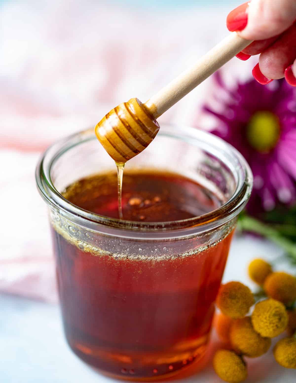 Honey wand dipped in a jar of vegan honey.
