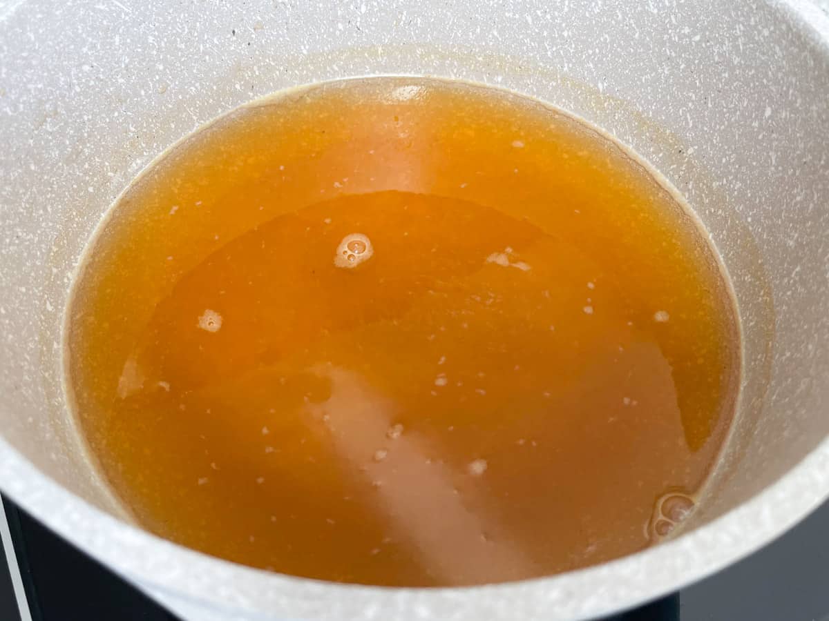 Saucepan filled with sugar dissolved in apple juice.