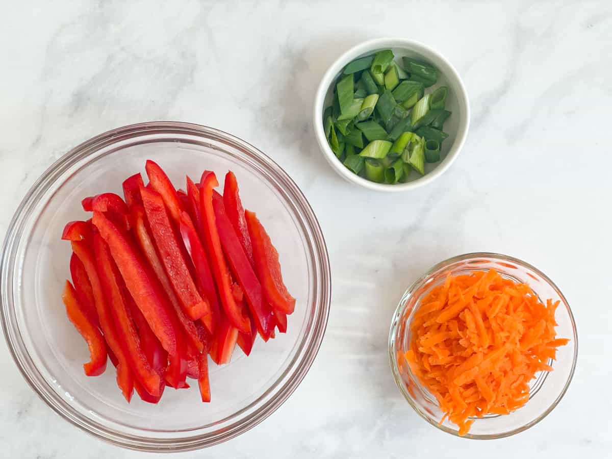 Sliced red peppers, shredded carrots, and diced green onion.