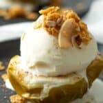 Vegan baked apple topped with ice cream and granola.