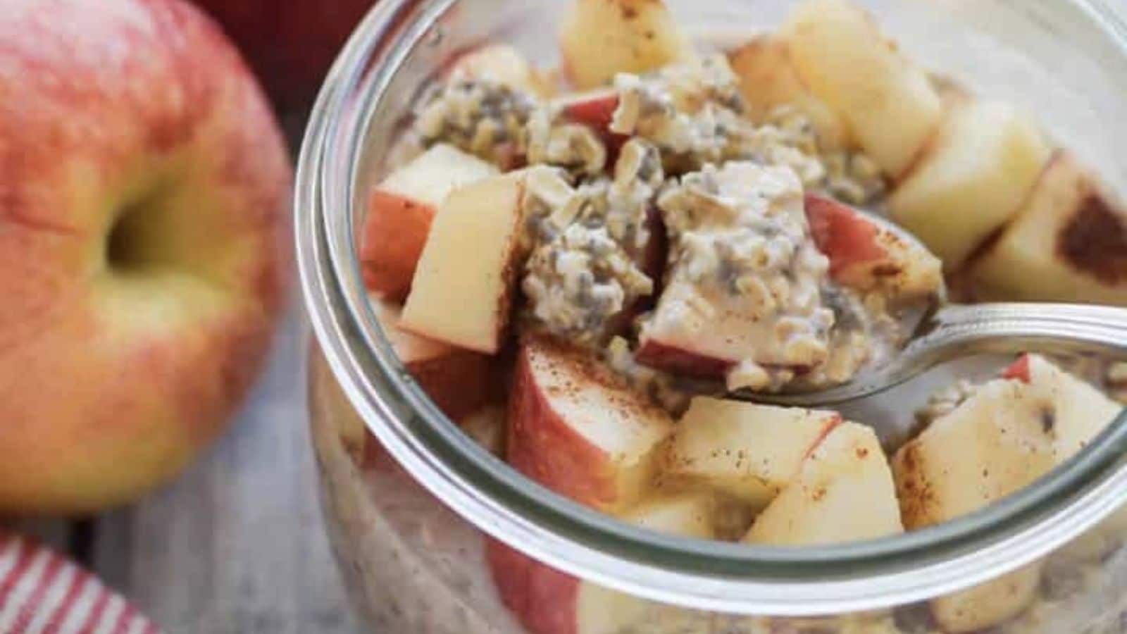 Spoon dipped into apple overnight oats.
