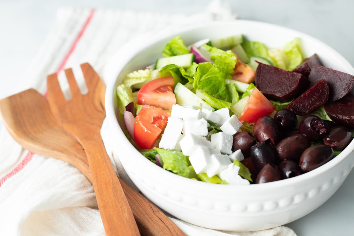 Vegan Greek salad in a white bowl.
