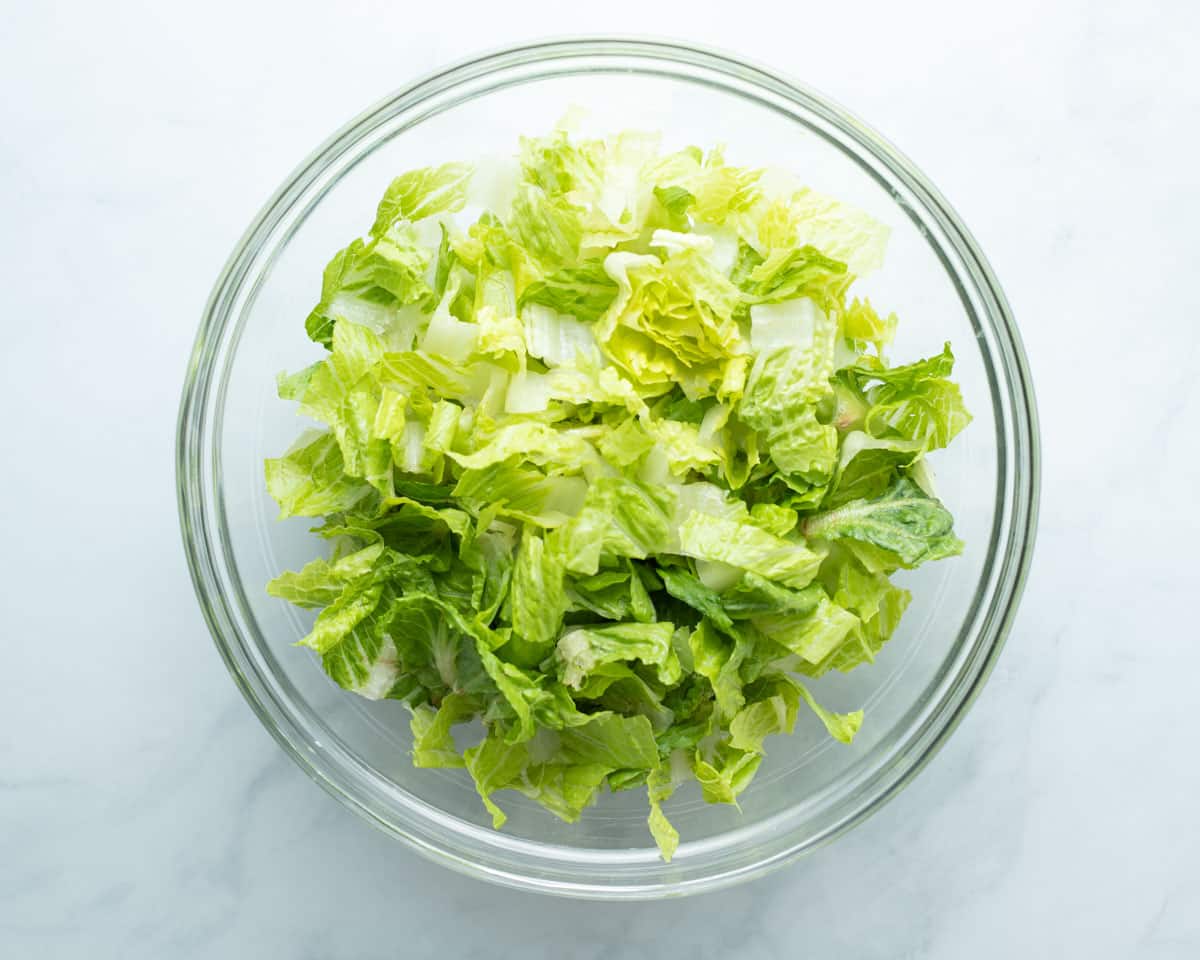 Chopped lettuce in glass bowl.