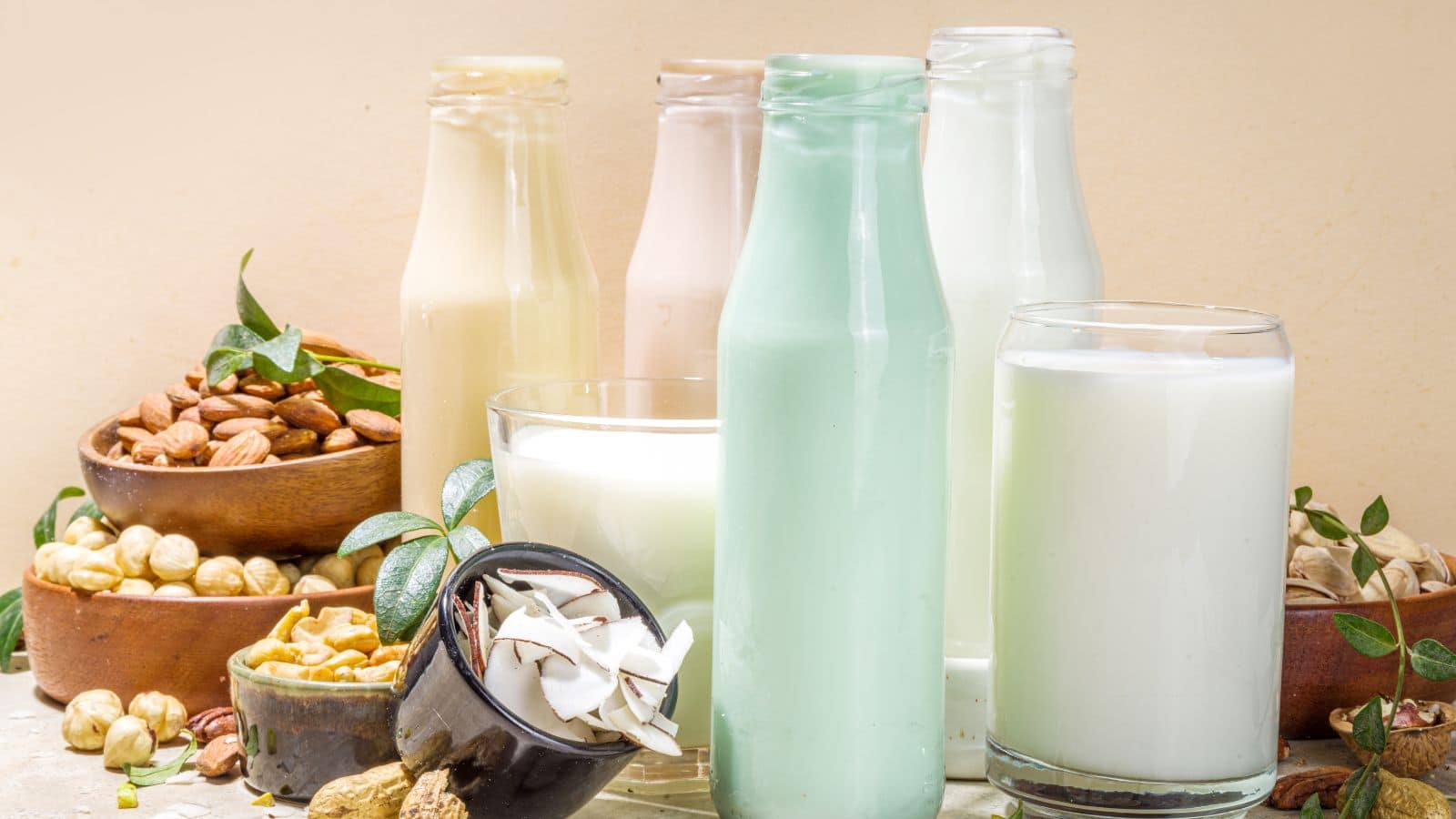 Various types of flavored nut milk in glasses and jugs. 