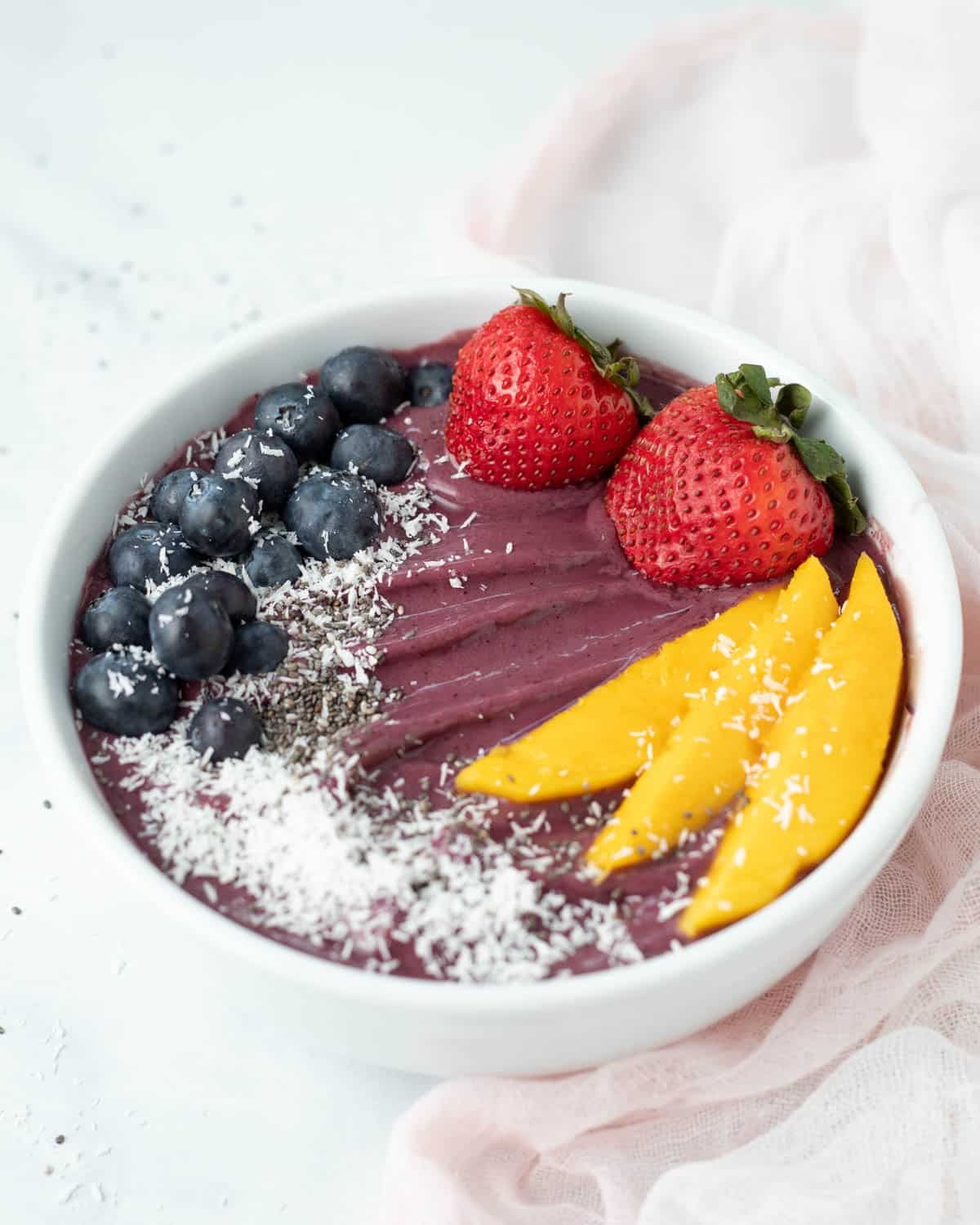 Acai bowl topped with fresh fruit, coconut flakes, and chia seeds.
