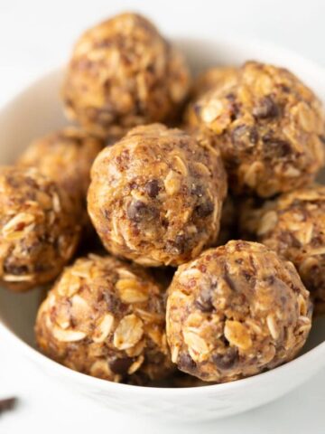 Vegan protein balls with oats and chocolate chips in a white bowl.