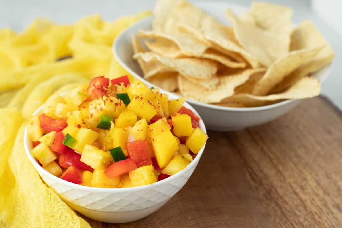 Pineapple mango salsa served with a side of tortilla chips.