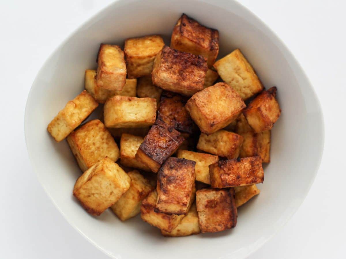 Crispy spicy air fryer tofu in white bowl.
