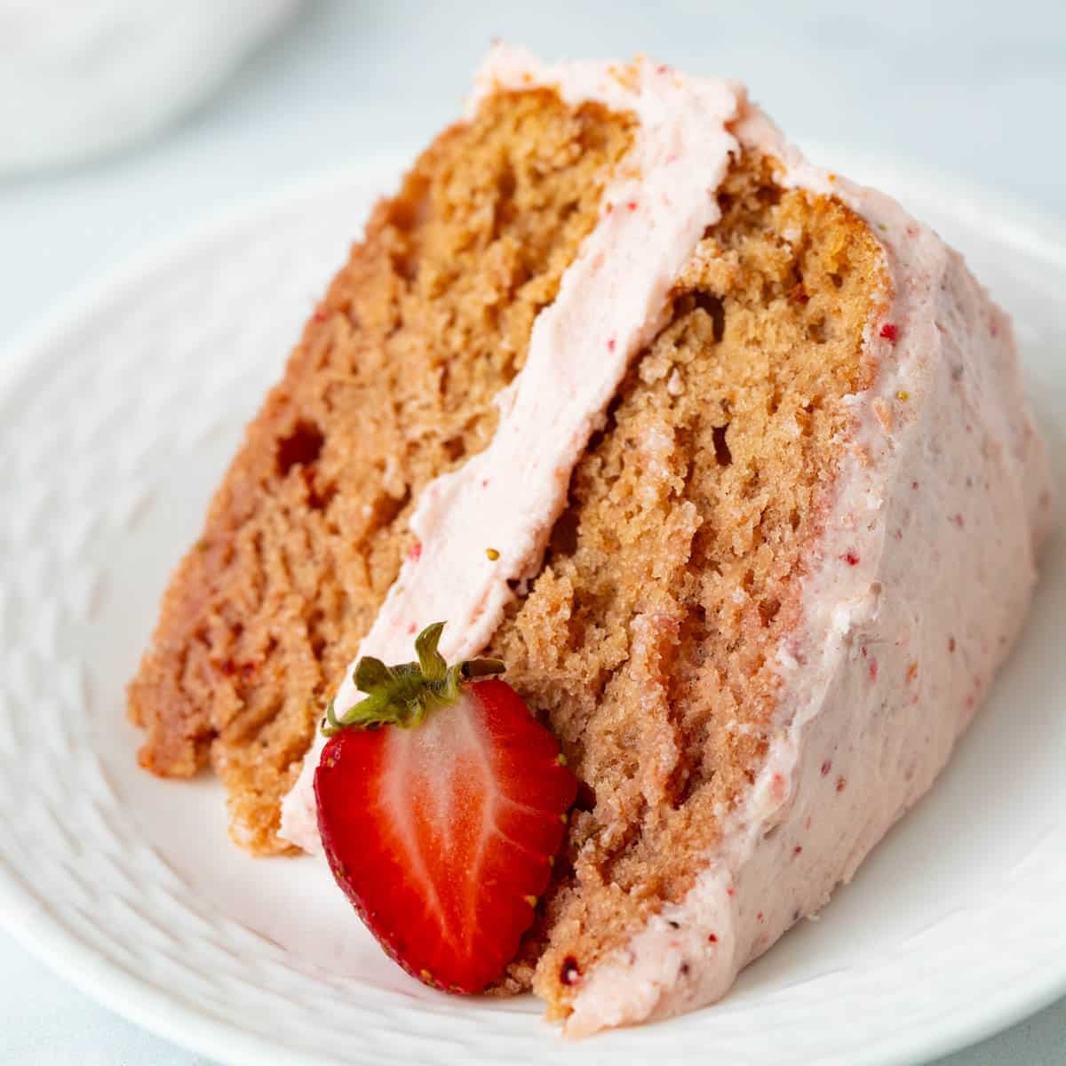 Slice of vegan strawberry cake on a plate. 