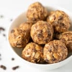 Vegan protein balls with oats and chocolate chips in a white bowl.