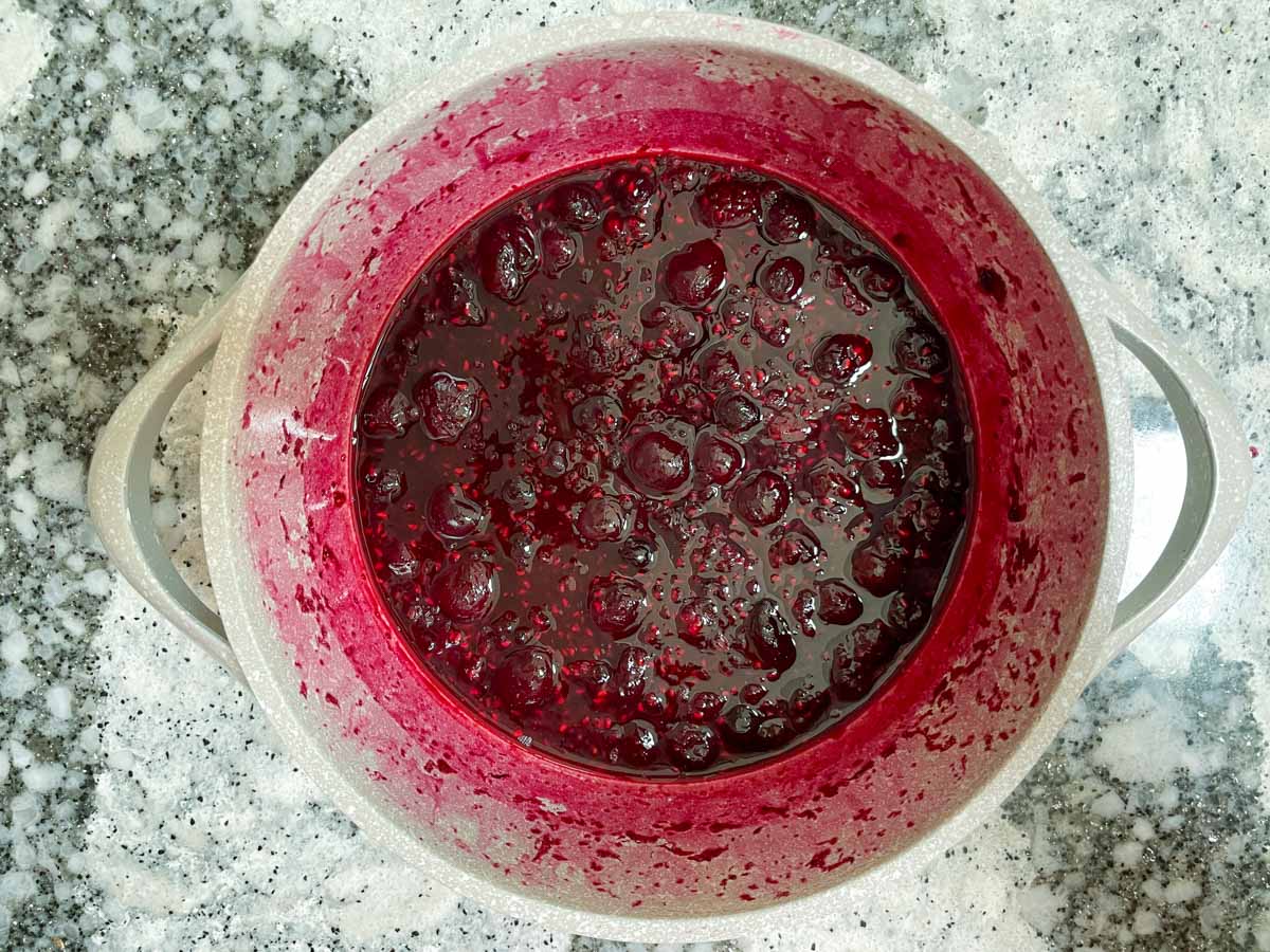 Cooked down berry compote in pot.
