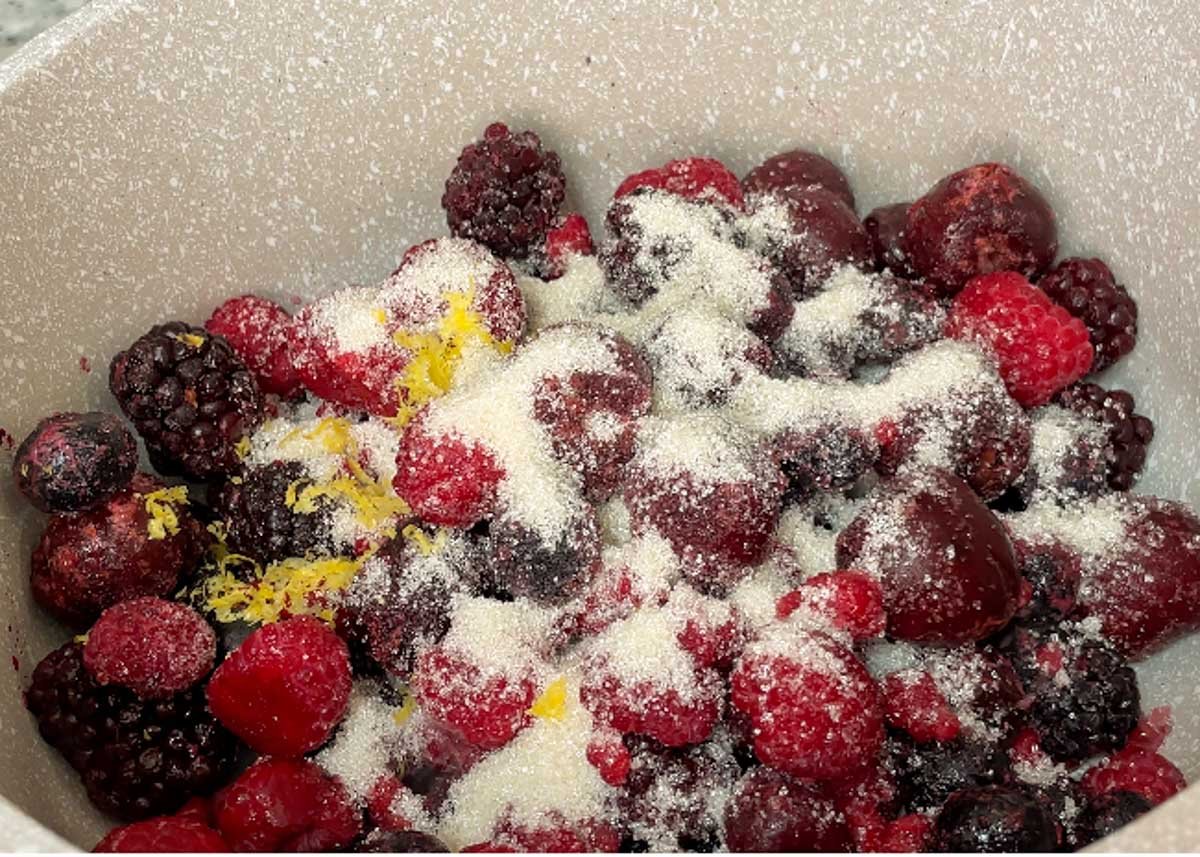Frozen berries, sugar, lemon zest in pot.
