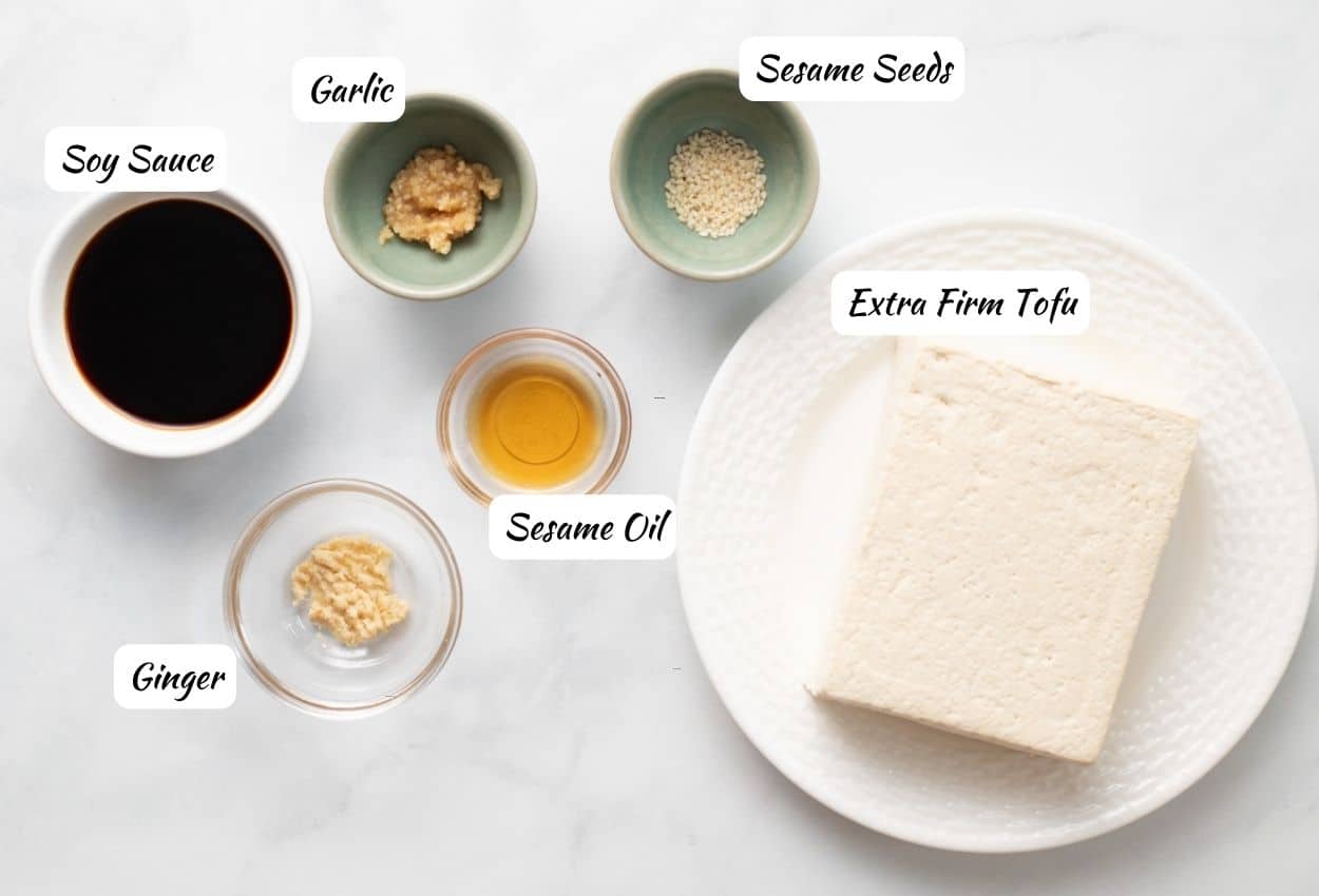 Teriyaki tofu marinade ingredients: tofu, sesame oil, ginger, soy sauce, garlic, sesame seeds.

