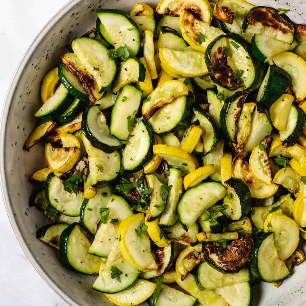 Roasted zucchini and yellow squash in a serving bowl.