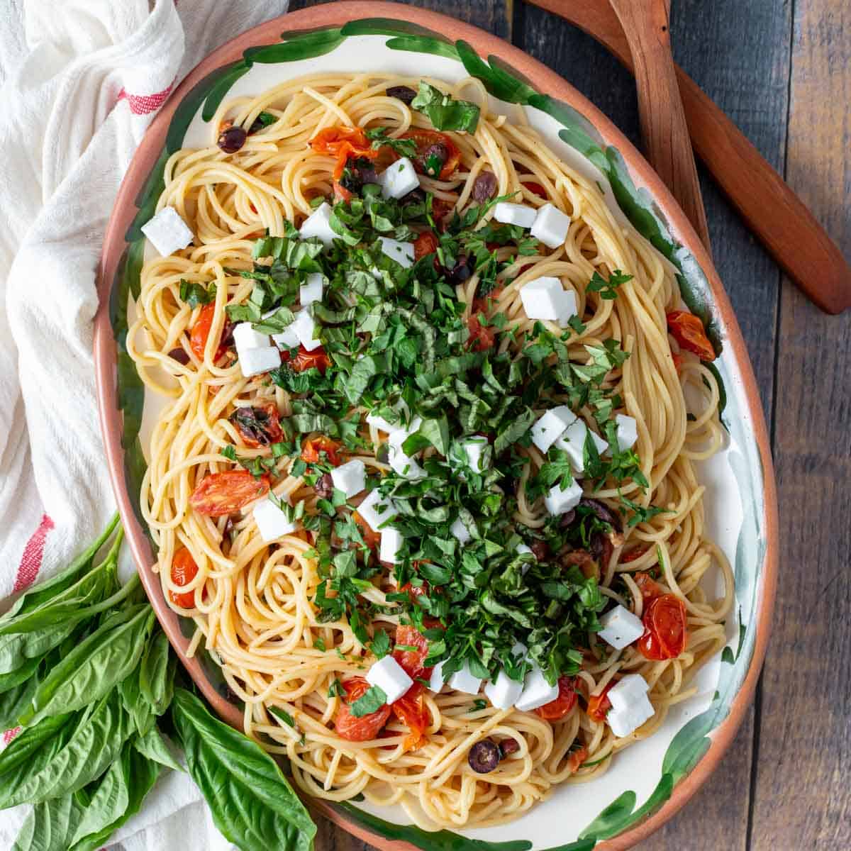 Greek spaghetti topped with fresh herbs and feta cheese.
