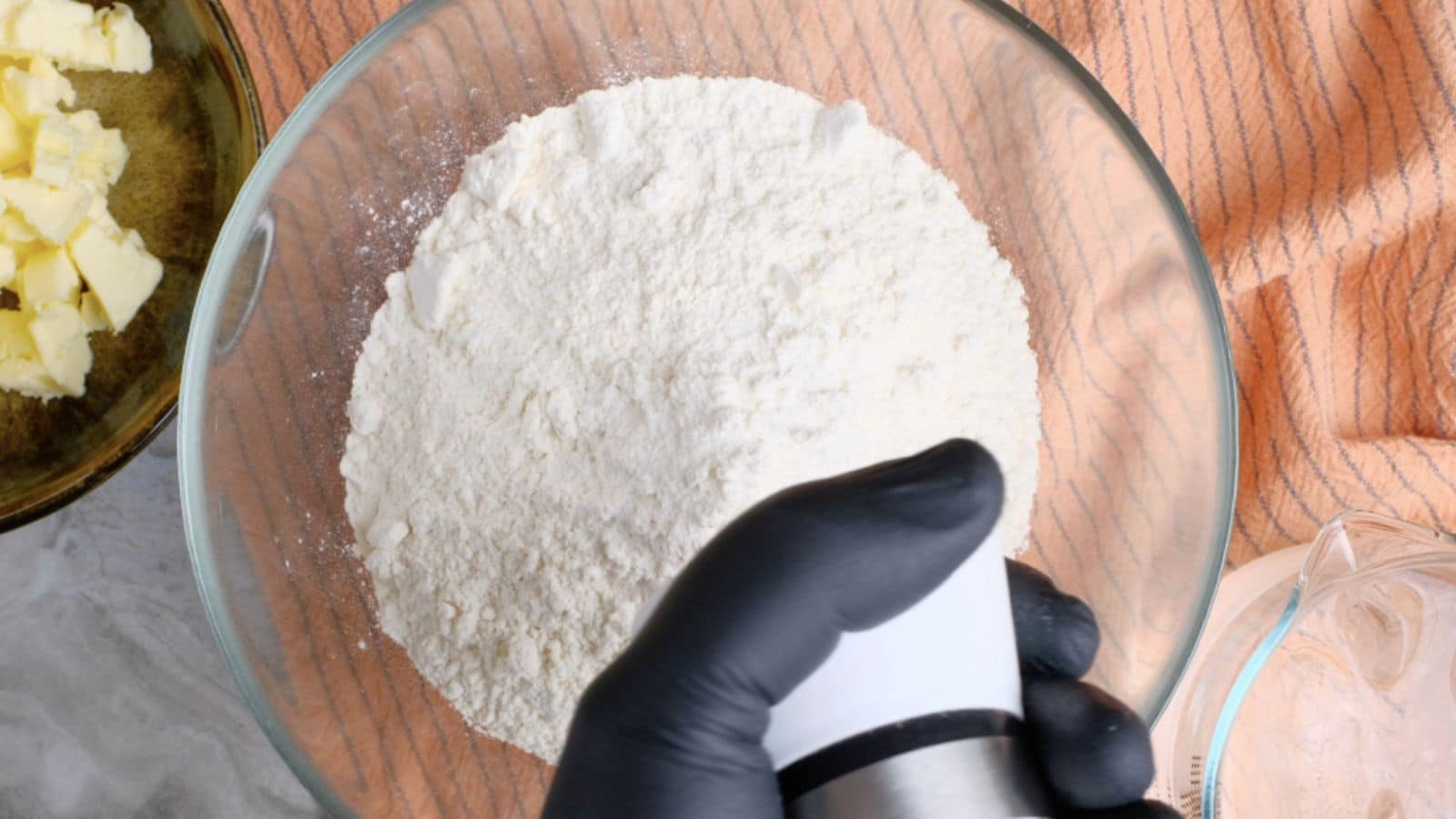 Adding salt to a bowl of flour.
