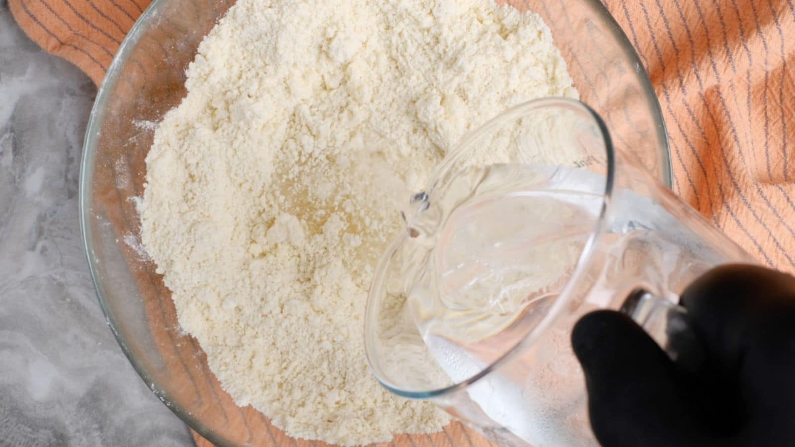 Adding cold water to bowl of flour and butter.
