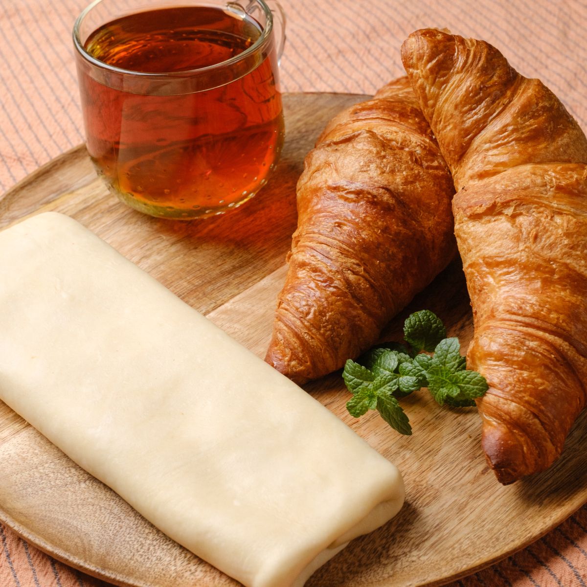 Vegan puff pastry sheet served with cup of tea and croissants.
