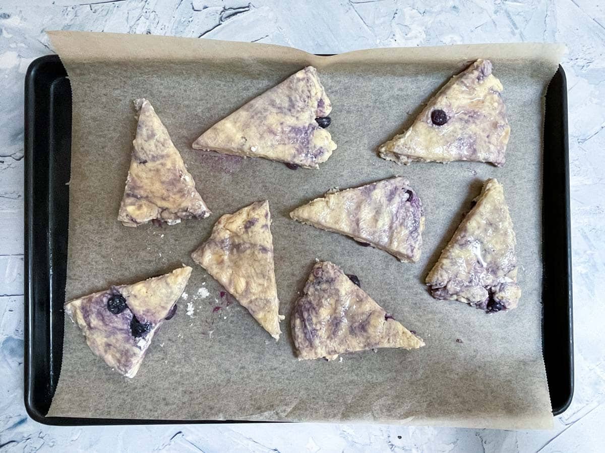 Triangle scone dough on baking sheet.
