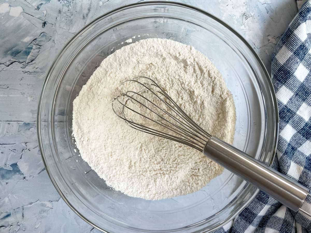 Whisking flour in glass mixing bowl.
